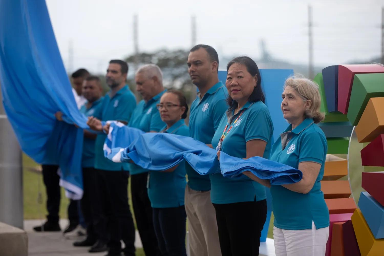 Personas sostienen la bandera de Ciudad del Saber 