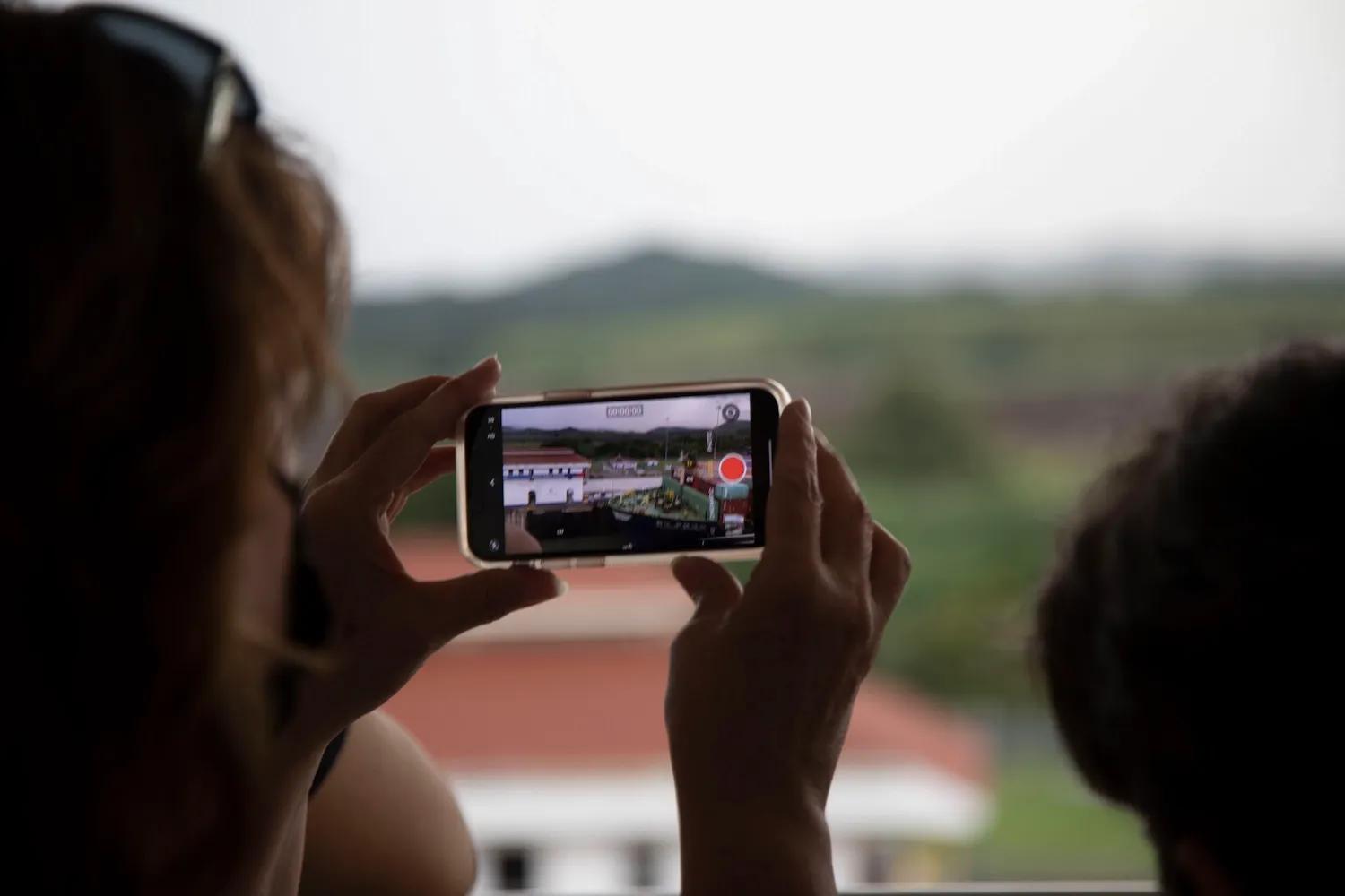 mujer con su celular toma una fotografía del campus de Ciudad del Saber